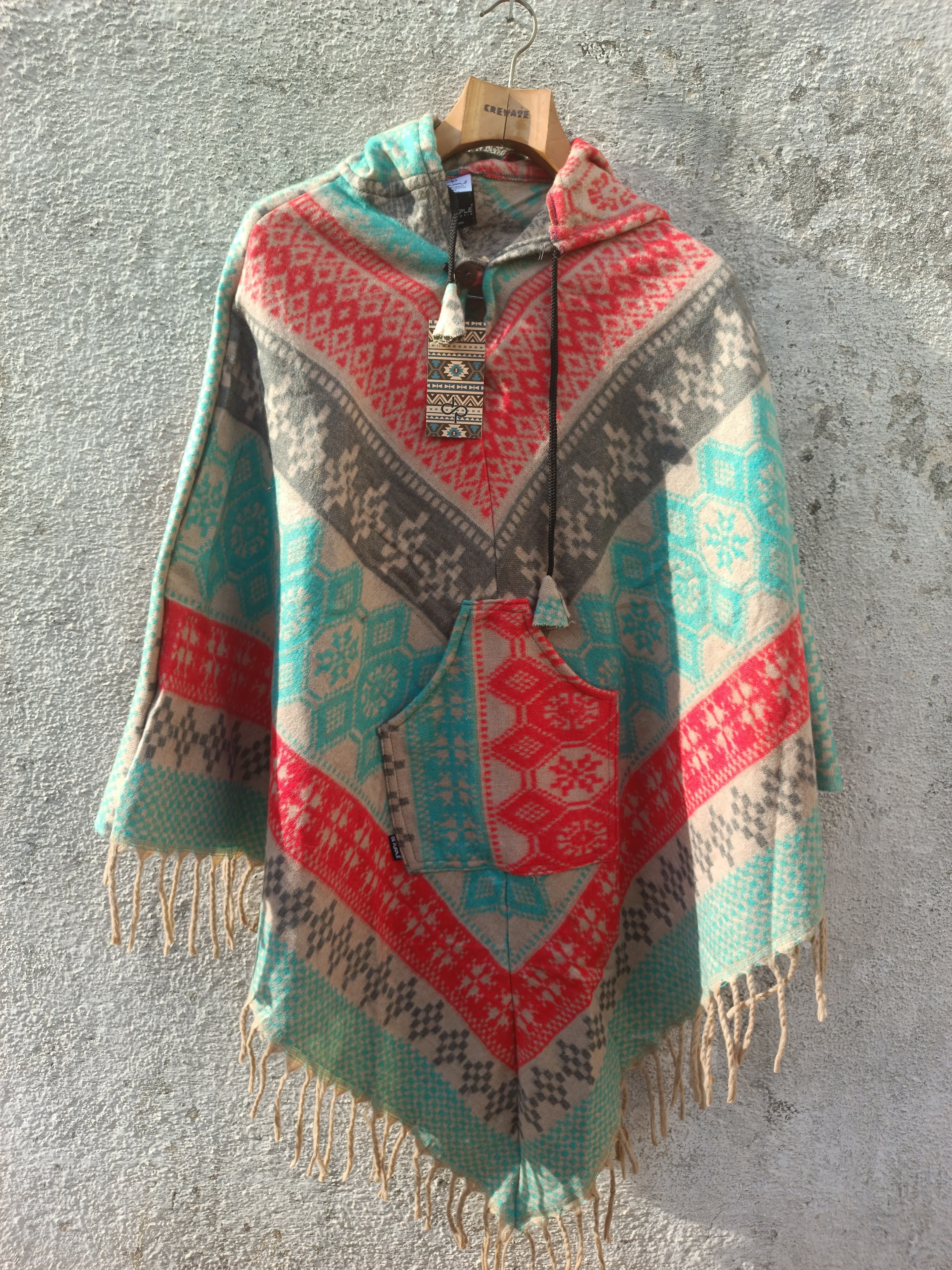 Red and light green multicolored printed Poncho with a drawstrring hoody,front pocket with a comfortable design our poncho is made from pure, soft, and breathable wool.